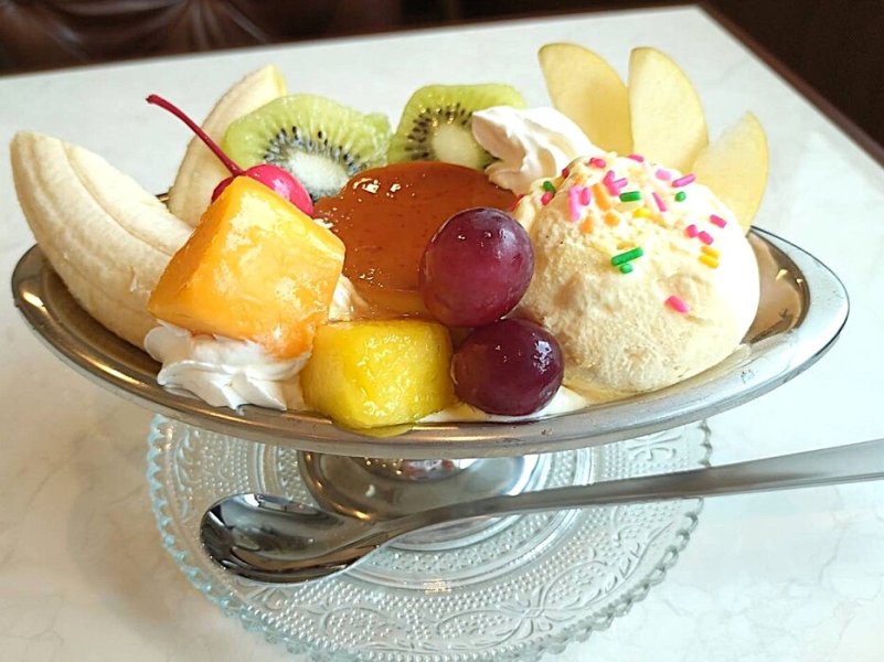 プリンを中心に、色とりどりのフルーツとバニラアイスを添えた、憧れのプリンアラモード